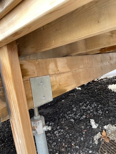 Helical pile bracket bolted to deck framing